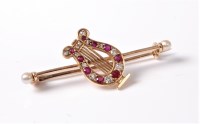 Lot 2542 - A ruby and diamond lyre brooch, the...