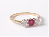 Lot 2548 - A three stone ruby and diamond ring, the...