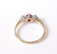 Lot 2548 - A three stone ruby and diamond ring, the...
