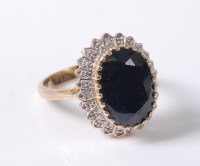 Lot 2636 - A 9ct sapphire and diamond ring, the oval deep...