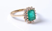Lot 2218 - An 18ct emerald and diamond cluster ring, the...