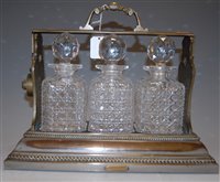 Lot 115 - A circa 1900 silver plated three-bottle...