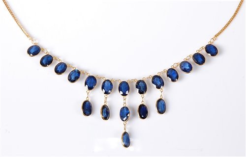 Lot 1157 - A '21k' sapphire fringe necklace, the oval...