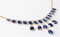 Lot 1157 - A '21k' sapphire fringe necklace, the oval...