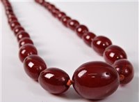Lot 380 - A faux cherry amber graduated bead necklace,...