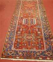 Lot 2632 - A Persian Heriz woollen hall runner, the red...