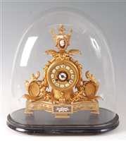 Lot 110 - A Victorian gilt metal mantel clock under...