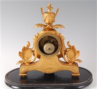 Lot 110 - A Victorian gilt metal mantel clock under...
