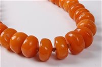 Lot 2180 - A butterscotch amber bead necklace, the...