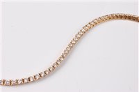 Lot 2275 - An 18ct diamond line bracelet, set with round...