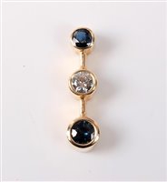 Lot 2250 - A three stone sapphire and diamond pendant,...