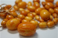 Lot 2183 - A butterscotch amber bead necklace, the oval...