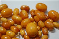 Lot 2183 - A butterscotch amber bead necklace, the oval...