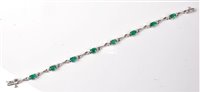 Lot 2240 - An emerald and diamond bracelet, the oval...
