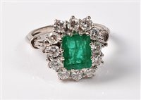 Lot 2233 - An emerald and diamond cluster ring, the...