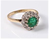 Lot 2214 - An 18ct emerald and diamond cluster ring, the...
