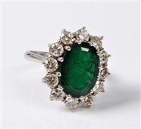 Lot 2231 - An emerald and diamond cluster ring, the oval...