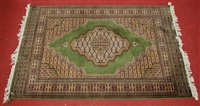 Lot 2635 - A Persian woollen green ground rug, the...