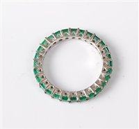Lot 2561 - An 18ct white gold emerald eternity ring, the...