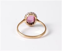 Lot 1188 - An 18ct pink sapphire and diamond ring, the...