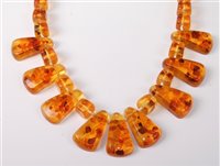 Lot 302 - An amber necklace, the half set tapered...