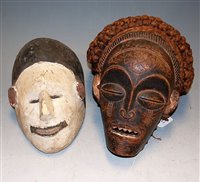 Lot 24 - An African carved softwood tribal mask; and...