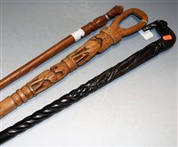 Lot 98 - An African carved ebony walking cane; together...