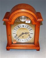 Lot 125 - A reproduction yew wood cased domed top mantel...