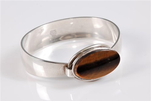 Lot 157 - A Danish silver and tigers eye bangle by Niels...