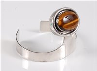 Lot 158 - A silver and tigers eye bangle, the oval...
