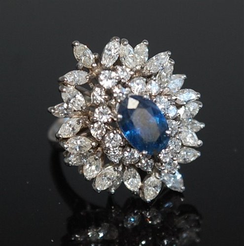 Lot 2177 - A sapphire and diamond cluster ring, the oval...