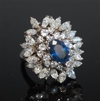 Lot 301 - A sapphire and diamond cluster ring, the oval...
