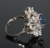 Lot 301 - A sapphire and diamond cluster ring, the oval...