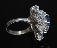 Lot 2177 - A sapphire and diamond cluster ring, the oval...
