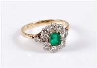 Lot 2562 - An 18ct emerald and diamond cluster ring, the...