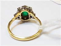 Lot 2562 - An 18ct emerald and diamond cluster ring, the...