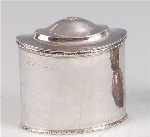 Lot 105 - A late Arts & Crafts hammered silver oval tea...