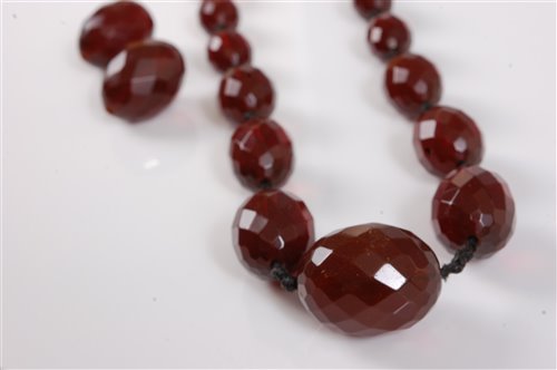 Lot 322 - A faux 'cherry amber' bead necklace, the...