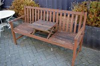 Lot 1124 - A stained and slatted teak three seater garden...