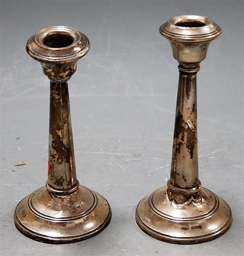 Lot 213 - A pair of George V silver table candlesticks...
