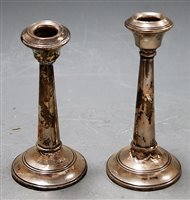 Lot 213 - A pair of George V silver table candlesticks...