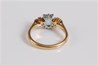 Lot 1172 - An 18ct three stone emerald and diamond ring,...