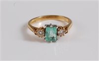 Lot 1172 - An 18ct three stone emerald and diamond ring,...
