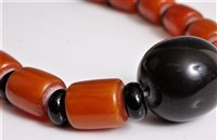 Lot 2571 - A faux butterscotch amber and black bead...
