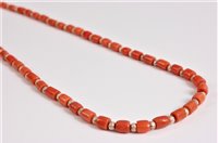 Lot 2582 - A coral and silver bead necklace, the barrel...