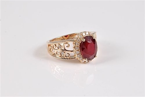 Lot 1187 - A 14k treated ruby and diamond ring, the oval...