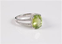 Lot 1173 - A 14 peridot and diamond ring, the oval...