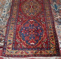 Lot 1554 - A Persian woollen Heriz runner, the red ground...