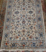 Lot 1557 - A Persian woollen Kashan rug, the cream ground...