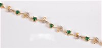 Lot 2568 - A 14k emerald and diamond bracelet, the round...